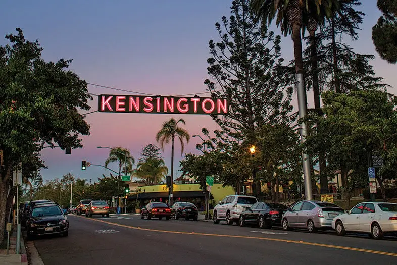 Kensington neon neighborhood sign over the street at dusk, San Diego.