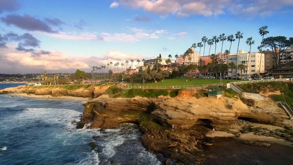 La Jolla coastline with ocean cliffs and palm-lined neighborhood.