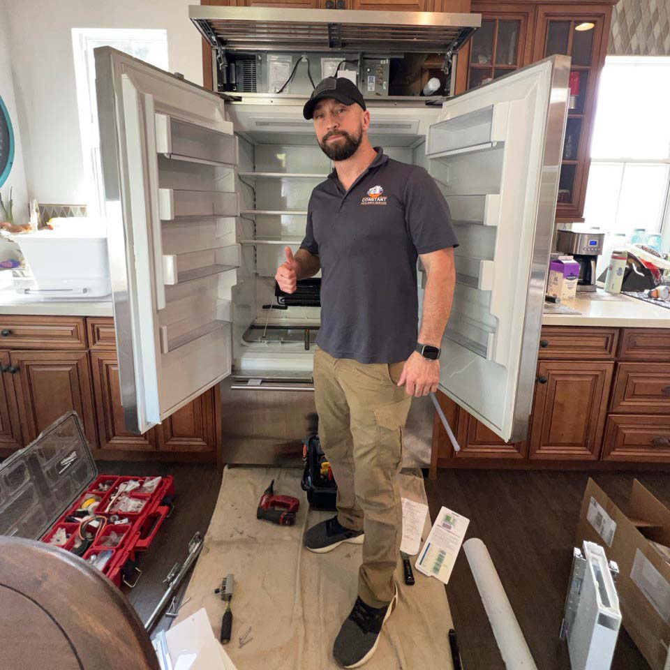 Constant Appliance technician servicing a built-in refrigerator in San Diego