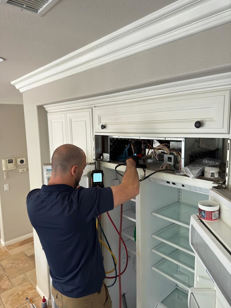 Professional freezer repair technician servicing upright freezer in modern home